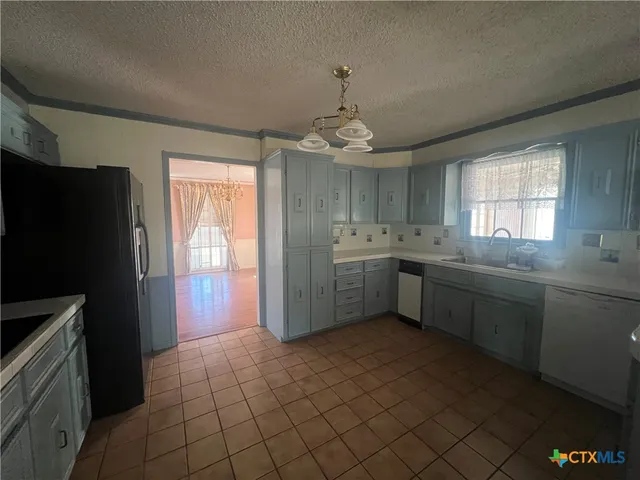 a kitchen with a sink a refrigerator and window