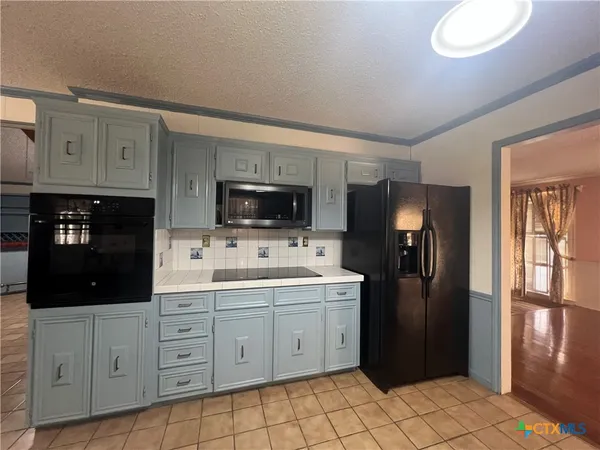 a kitchen with a refrigerator stove and cabinets