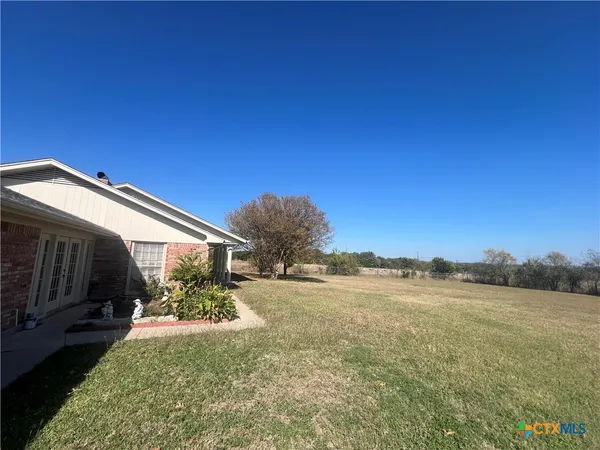 a view of a backyard with plants and lake view