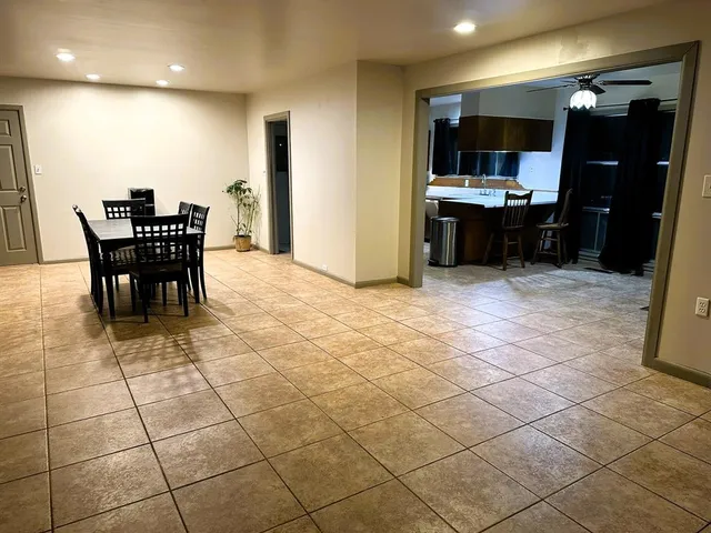 a view of kitchen with stainless steel appliances dining table chairs and a projector