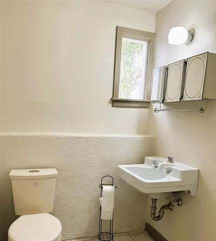 a bathroom with a toilet sink and mirror