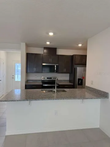 a kitchen with stainless steel appliances a sink a stove a microwave a sink and cabinets