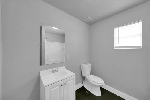 a bathroom with a sink a toilet and a window