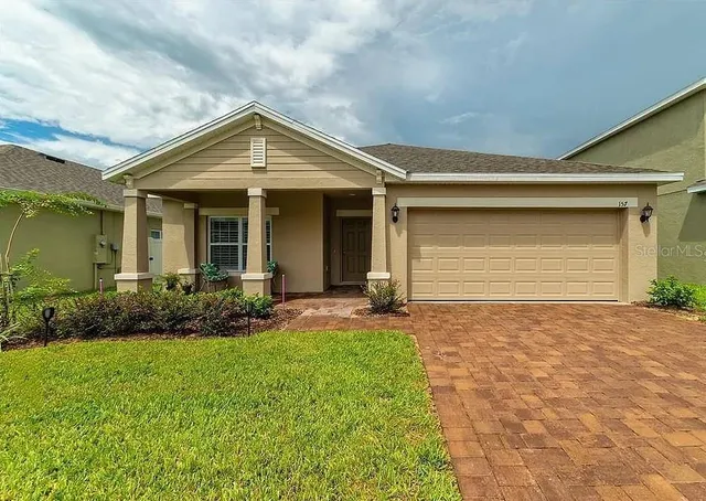 a view of backyard of house with green space