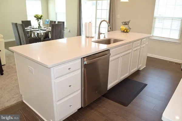 a kitchen with a sink a counter space and wooden floor