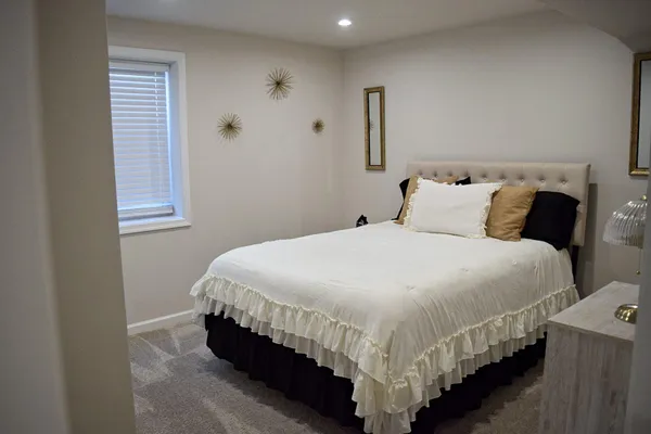 a large bed sitting in a bedroom next to a window