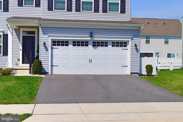 a front view of house with yard and garage