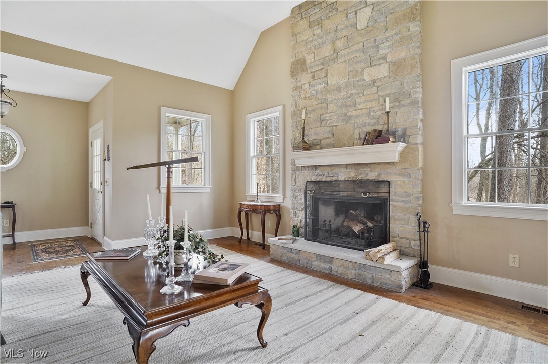 5612 Ridge Road Wadsworth, OH 44281 - Photo 6 of 33 Living room with wood-type flooring, a stone fireplace, and vaulted ceiling