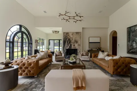 a living room with furniture chandelier and a large window
