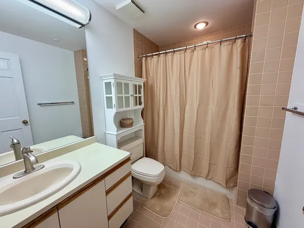 a bathroom with a granite countertop sink toilet and shower