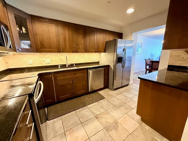 a kitchen with stainless steel appliances granite countertop a sink stove and refrigerator
