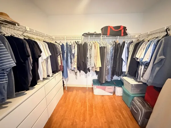 a view of walk in closet with clothes and shoes