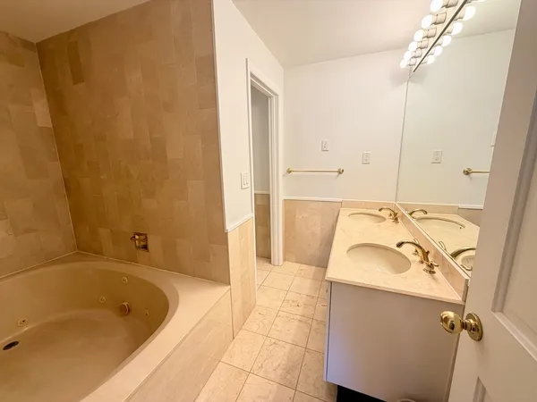 a bathroom with a tub sink and mirror