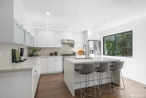 a kitchen with stainless steel appliances granite countertop a sink and a refrigerator
