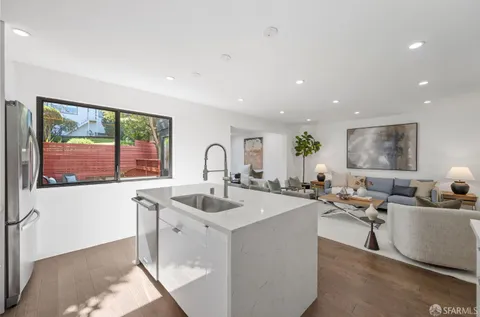 a open kitchen with sink a counter top space and living room view