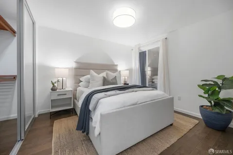 a bedroom with a bed and a potted plant