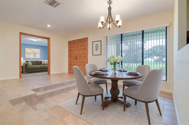 a living room with furniture a desk and a large window