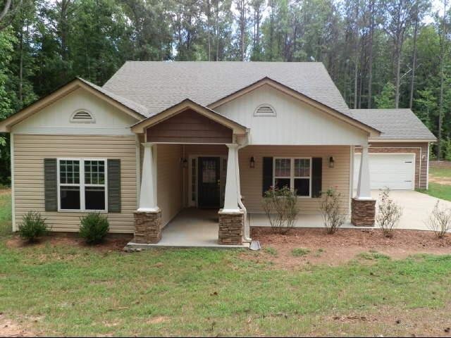 a view of a house with a yard and sitting area