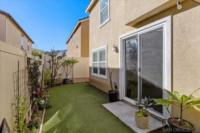 a living room with stainless steel appliances furniture a flat screen tv and kitchen view