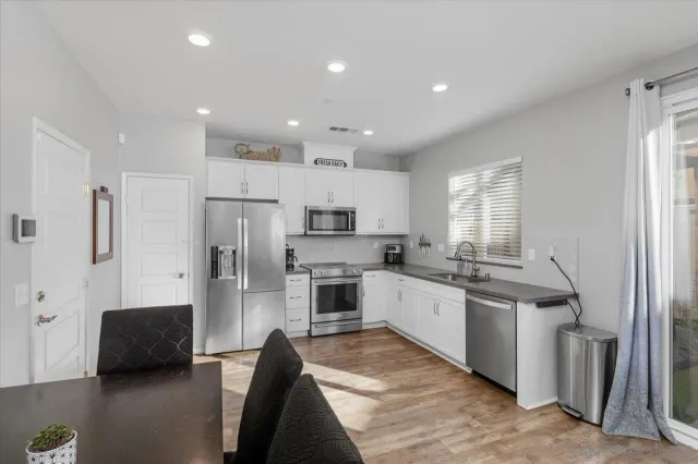 a kitchen with stainless steel appliances kitchen island granite countertop a stove top oven a sink and a refrigerator