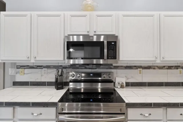 a dining room with furniture a chandelier and wooden floor