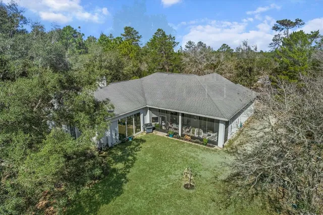 a front view of a house with a yard and large trees