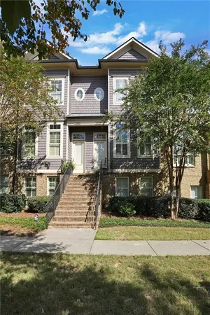 a front view of a house with a yard and potted plants