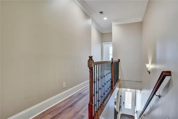 a view of a hallway with wooden floor and stairs