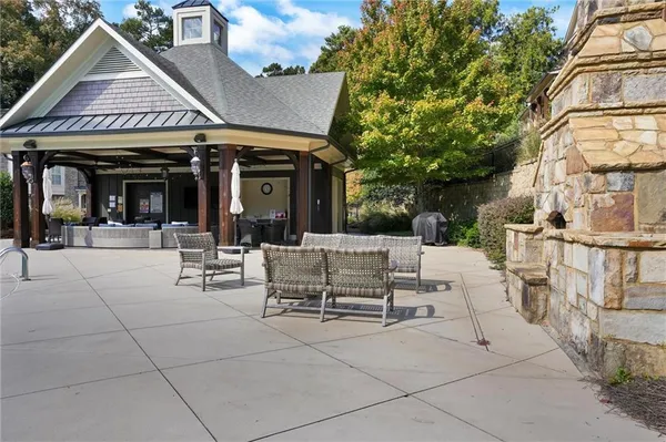 a view of a patio with couches and table potted plants and large tree