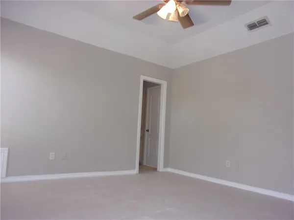 an empty room with a chandelier fan