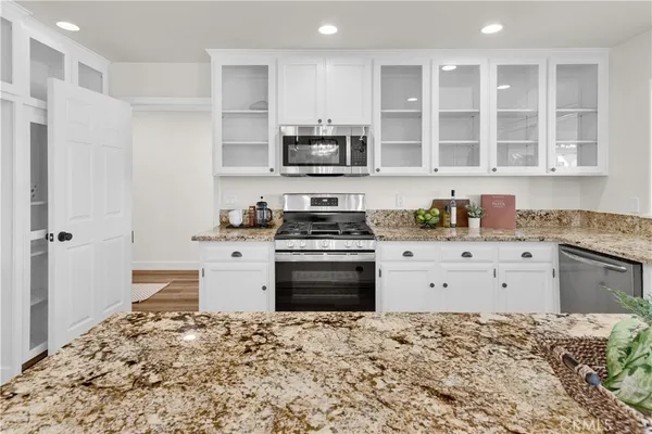 a kitchen with granite countertop a sink stove and cabinets