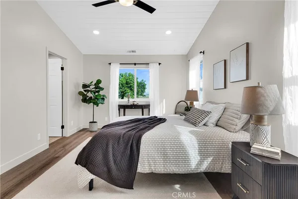 a spacious bedroom with a bed and a potted plant