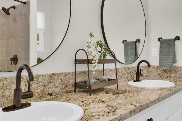 a bathroom with a granite countertop sink and a mirror