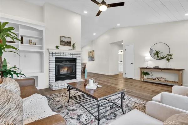 a living room with furniture a fireplace and wooden floor