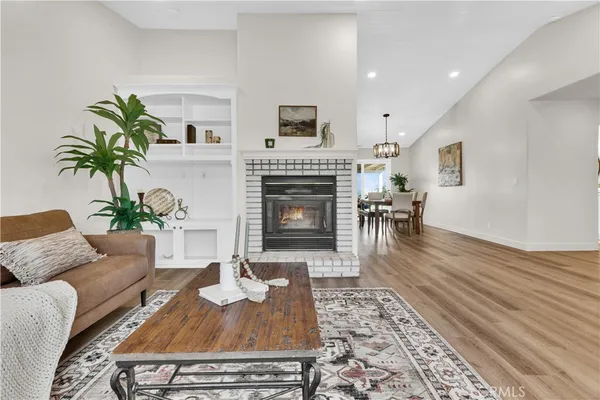 a dining room with wooden floor a chandelier a wooden table and chairs