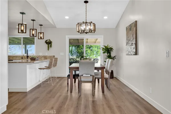 a kitchen with stainless steel appliances a table and chairs in it