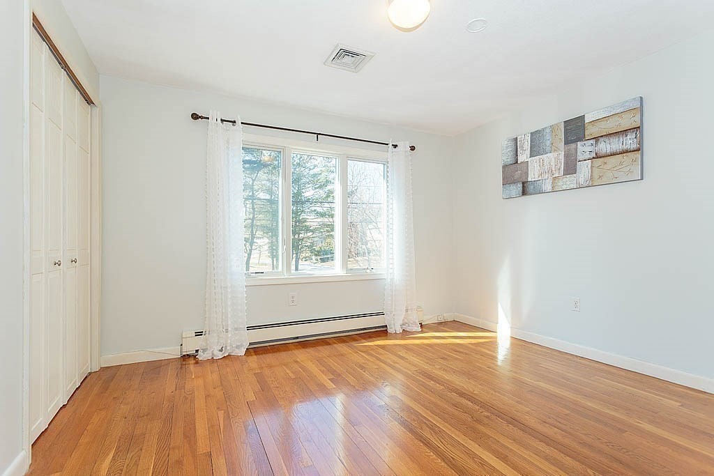 130 Worthen Road Lexington, MA 02421 - Photo 14 of 27 a view of an empty room with wooden floor and a window
