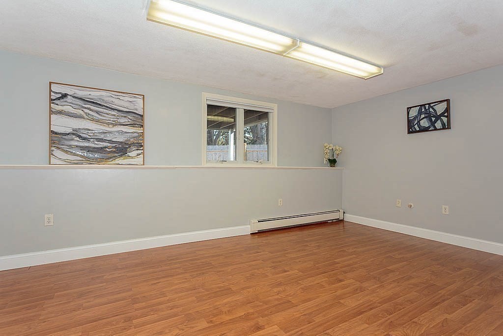 130 Worthen Road Lexington, MA 02421 - Photo 21 of 27 a view of an empty room with wooden floor and a window