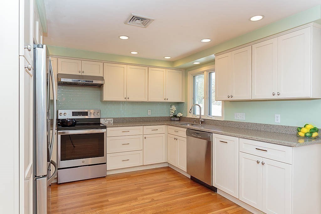 130 Worthen Road Lexington, MA 02421 - Photo 7 of 27 a kitchen with stainless steel appliances granite countertop a stove and white cabinets