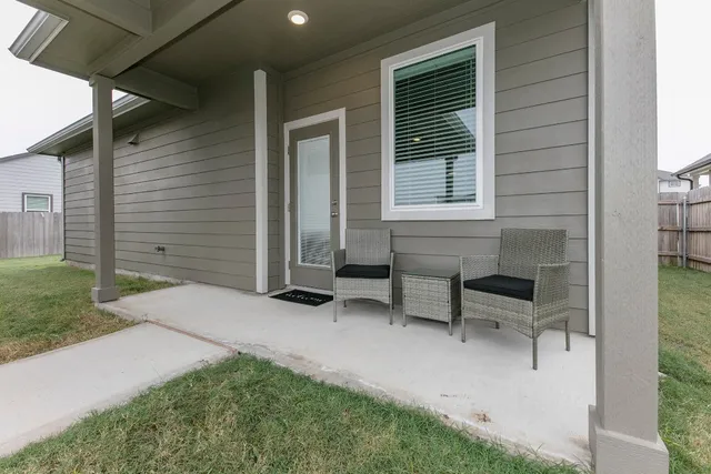 a backyard of a house with table and chairs