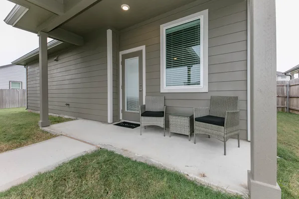 a backyard of a house with table and chairs