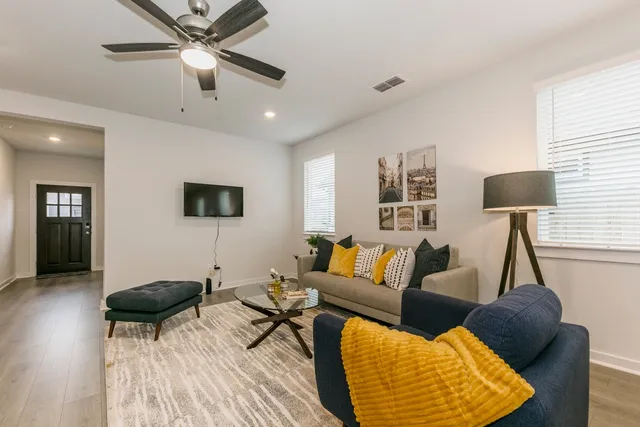 a living room with furniture and a wooden floor
