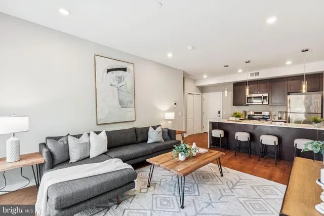 a living room with kitchen furniture and a wooden floor