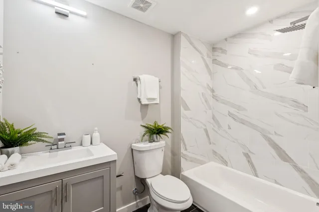 a bathroom with a sink a toilet a tub and shower