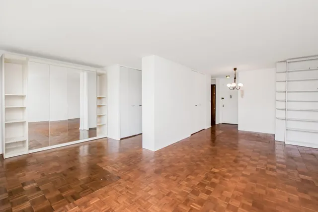 a view of a hallway with a window and a chandelier
