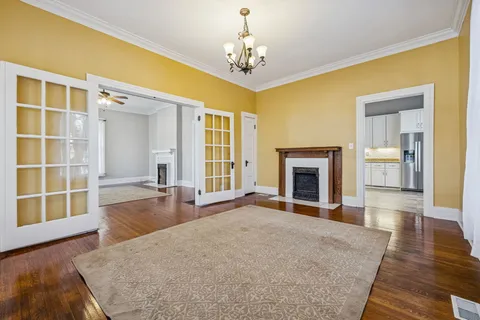 a view of a livingroom with wooden floor and a fireplace