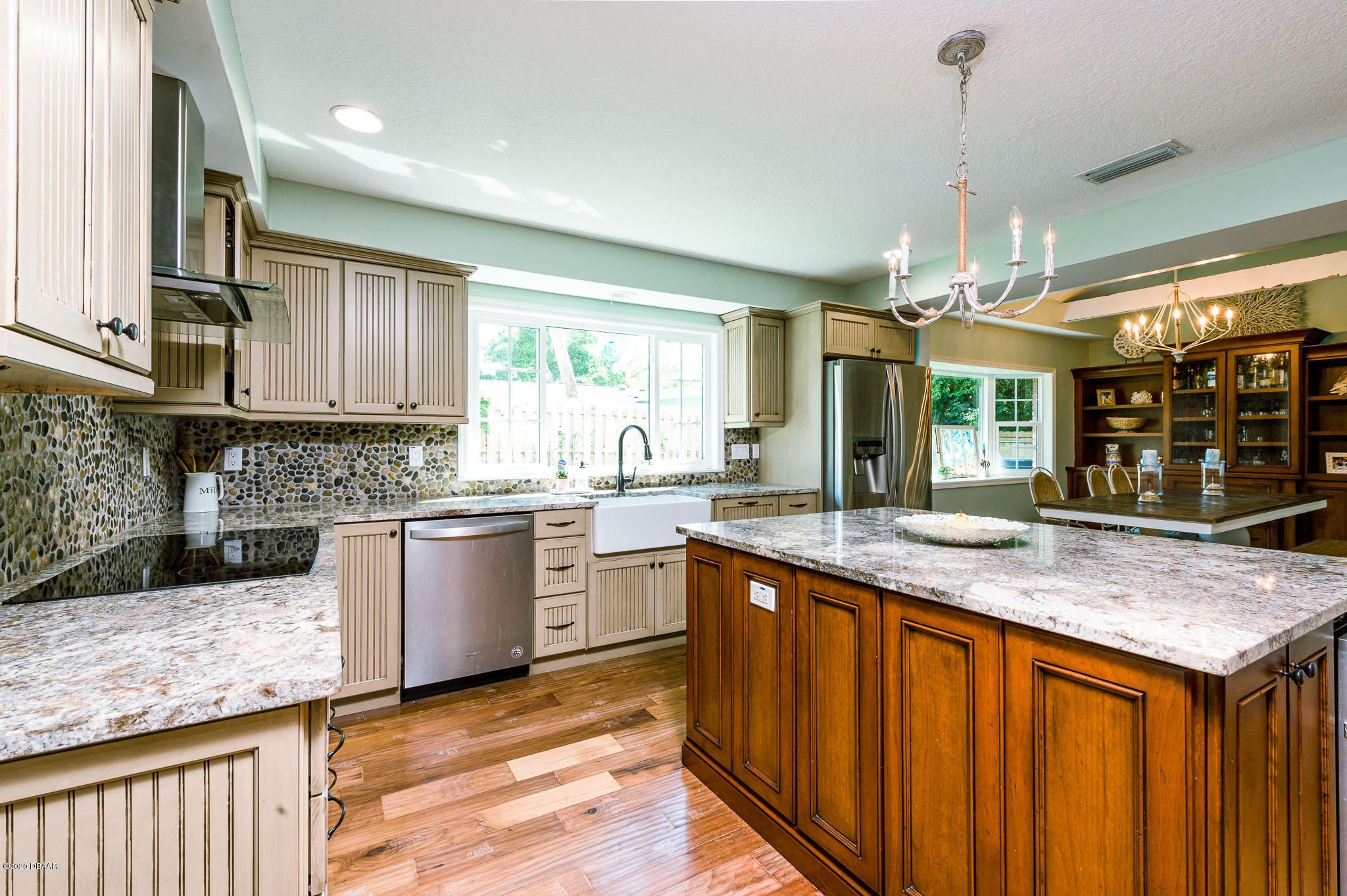 35 Neptune Avenue Ormond Beach, FL 32176 - Photo 26 of 58 a kitchen with stainless steel appliances granite countertop wooden cabinets a sink dishwasher a stove and a refrigerator with wooden floor