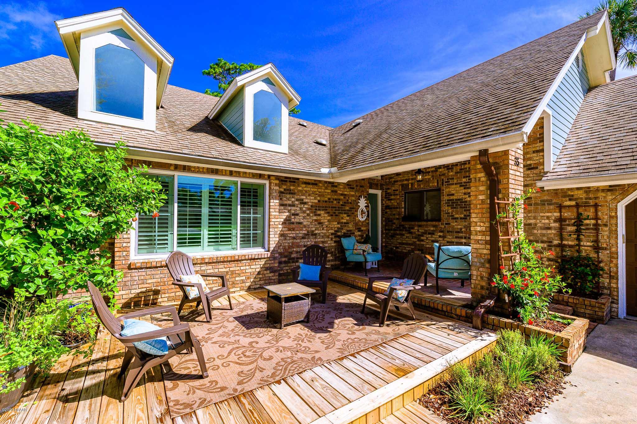 35 Neptune Avenue Ormond Beach, FL 32176 - Photo 4 of 58 a view of a patio with couches table and chairs and potted plants