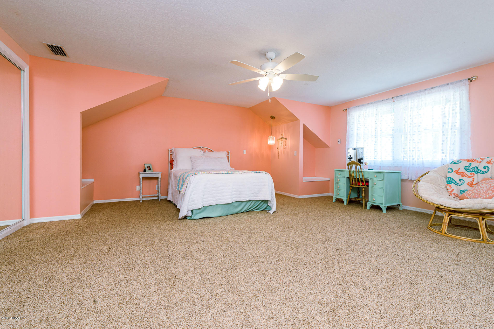 35 Neptune Avenue Ormond Beach, FL 32176 - Photo 42 of 58 a bedroom with a bed and a chandelier