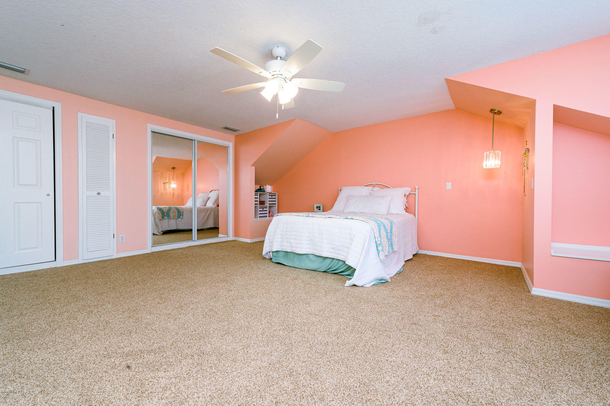 35 Neptune Avenue Ormond Beach, FL 32176 - Photo 43 of 58 a spacious bedroom with a bed and a chandelier
